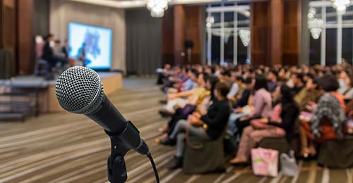 Microphone over the Abstract blurred photo of conference hall or seminar room with attendee background, Business meeting concept